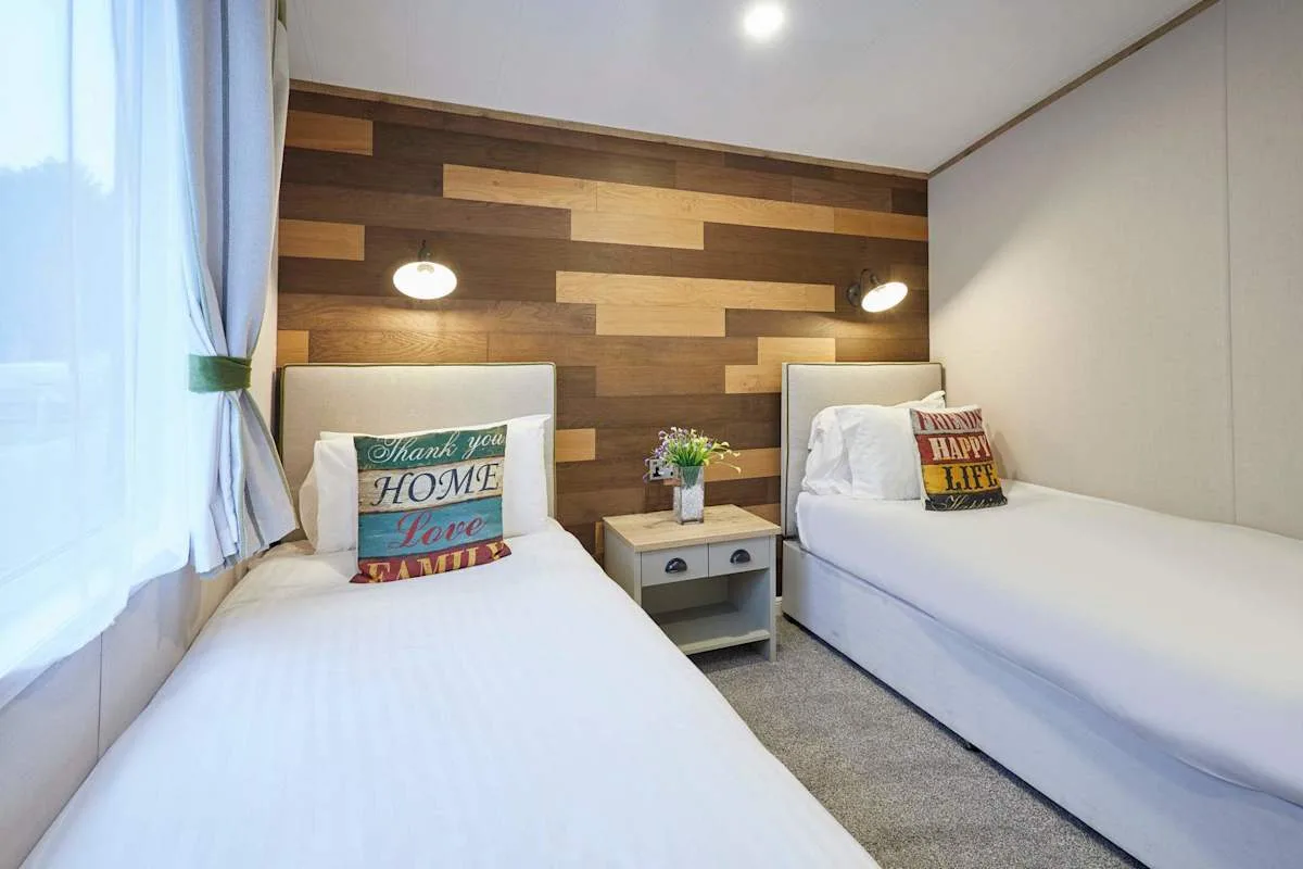 Un dormitorio con dos camas individuales y una pared decorativa revestida de madera.