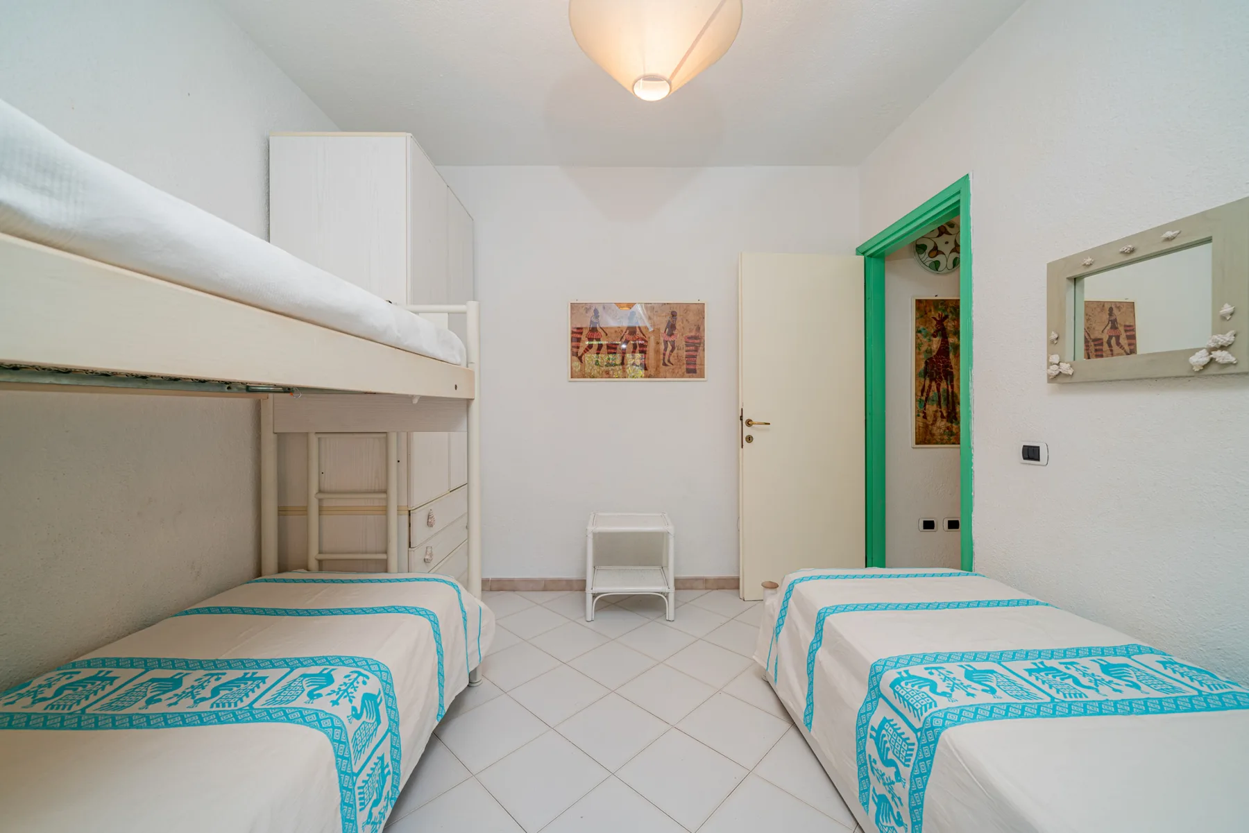 A bright bedroom with bunk beds and a single bed.