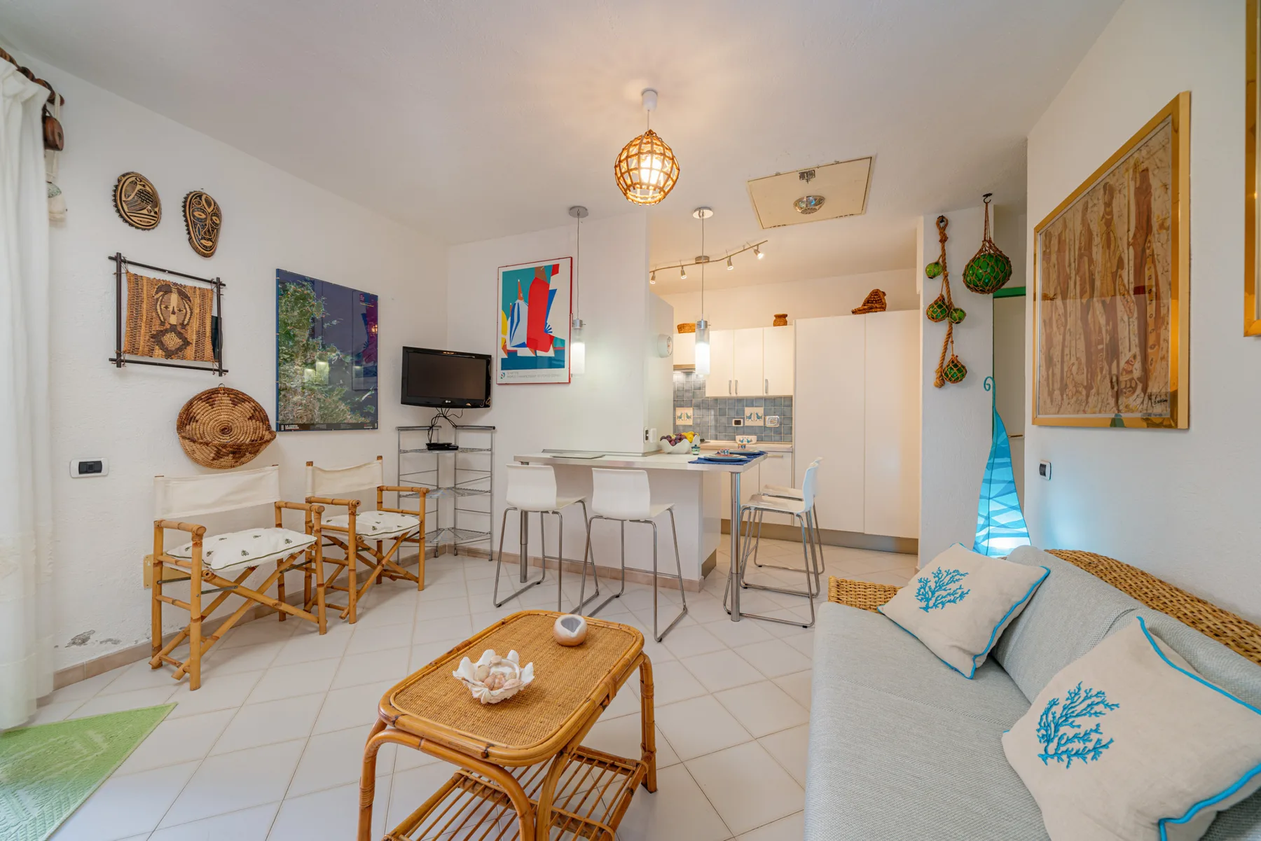 Una luminosa sala de estar y comedor con sofá, mesa y cocina pequeña.