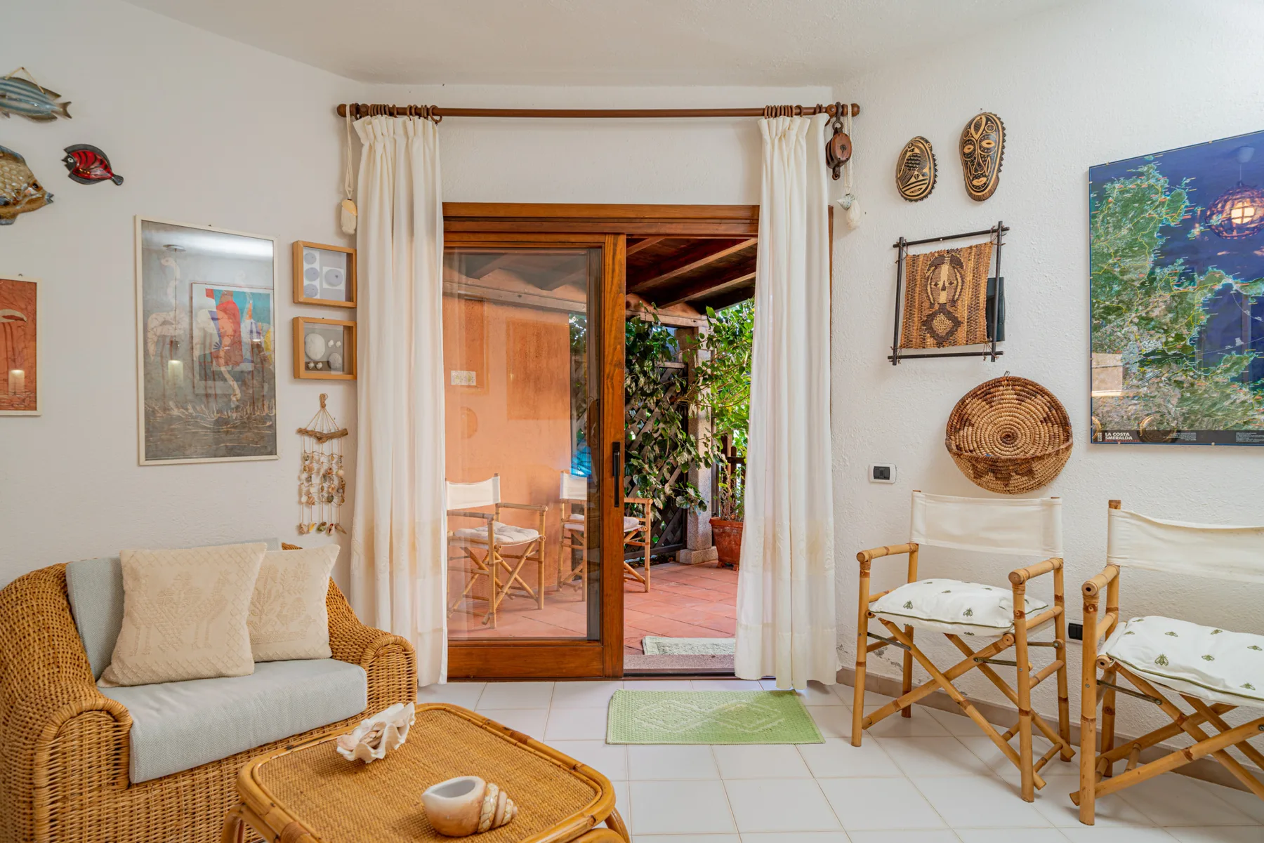 A bright sitting area opens through a glass door to a patio.