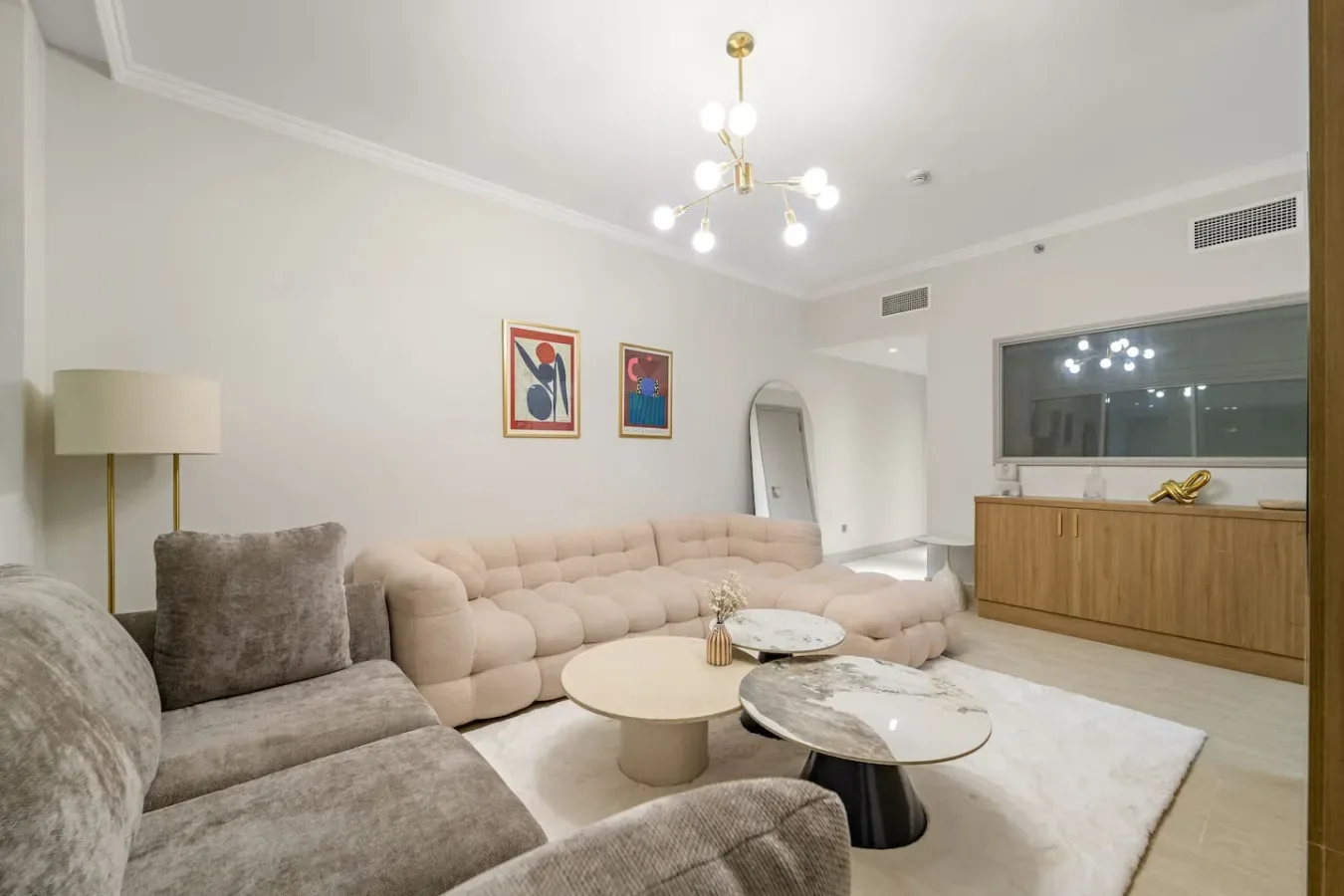 Una sala luminosa con asientos acolchados, mesas bajas y cuadros en la pared.