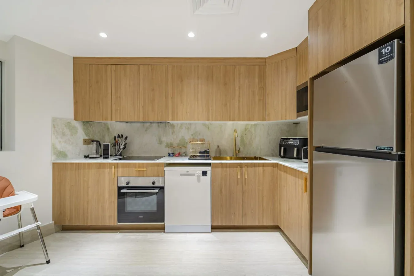 Una cocina moderna con gabinetes de madera, una estufa y un refrigerador.