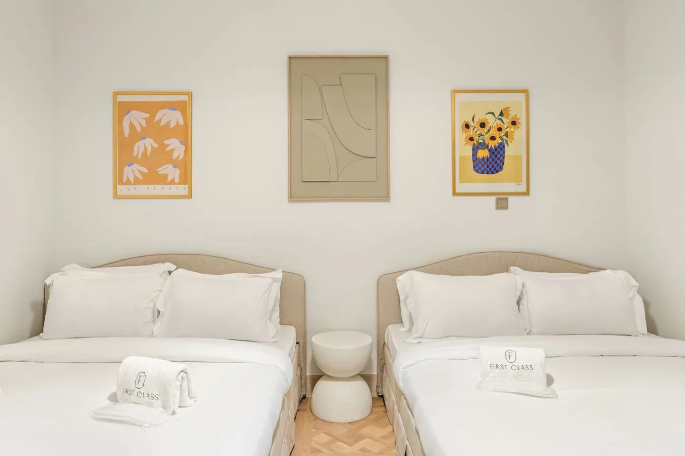Un dormitorio con dos camas y cuadros enmarcados en la pared.