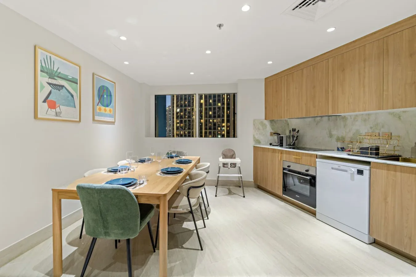 Un comedor con una mesa de madera junto a una cocina con gabinetes de madera clara.