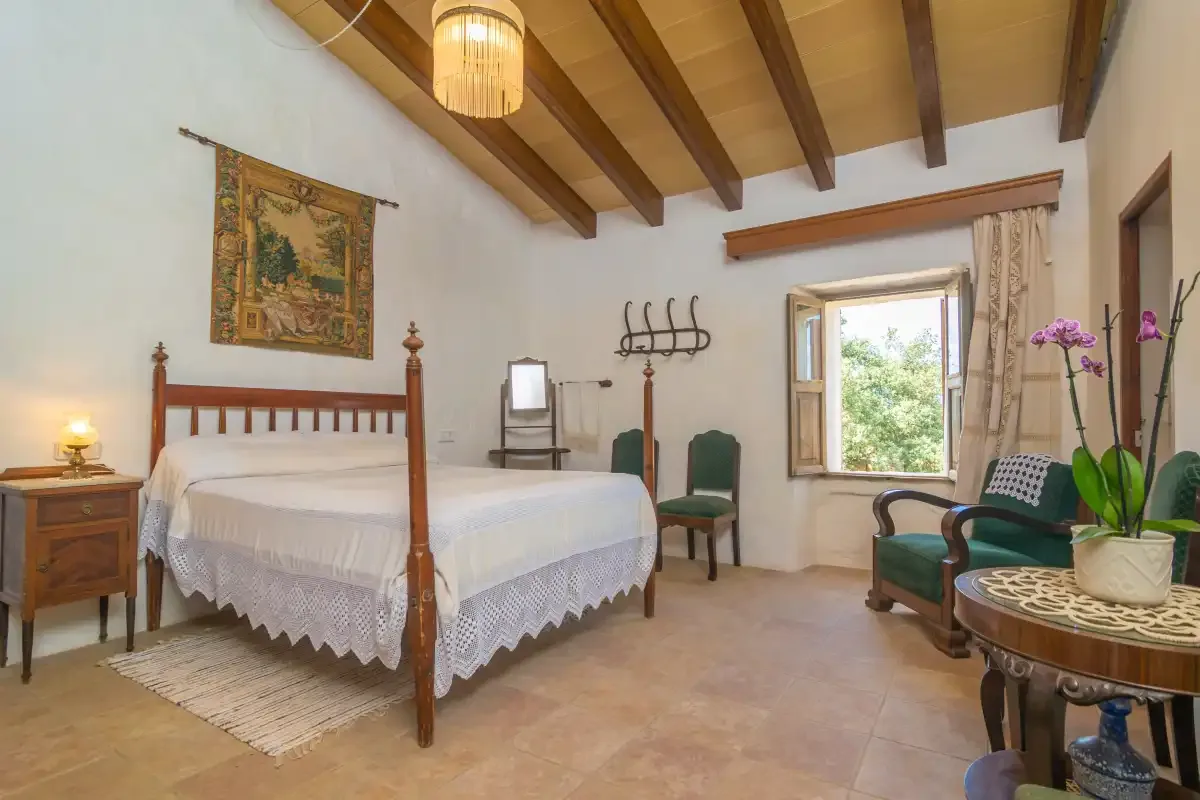 A bedroom with a wooden bed, a window, and seating.