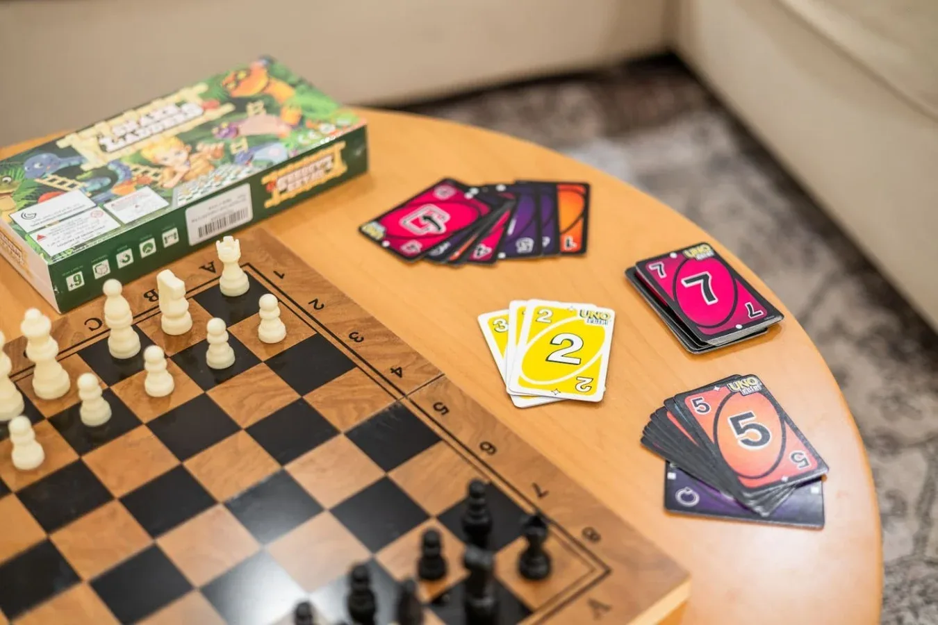 Una escena de juegos de mesa con un tablero de ajedrez y cartas de colores sobre una mesa de madera.
