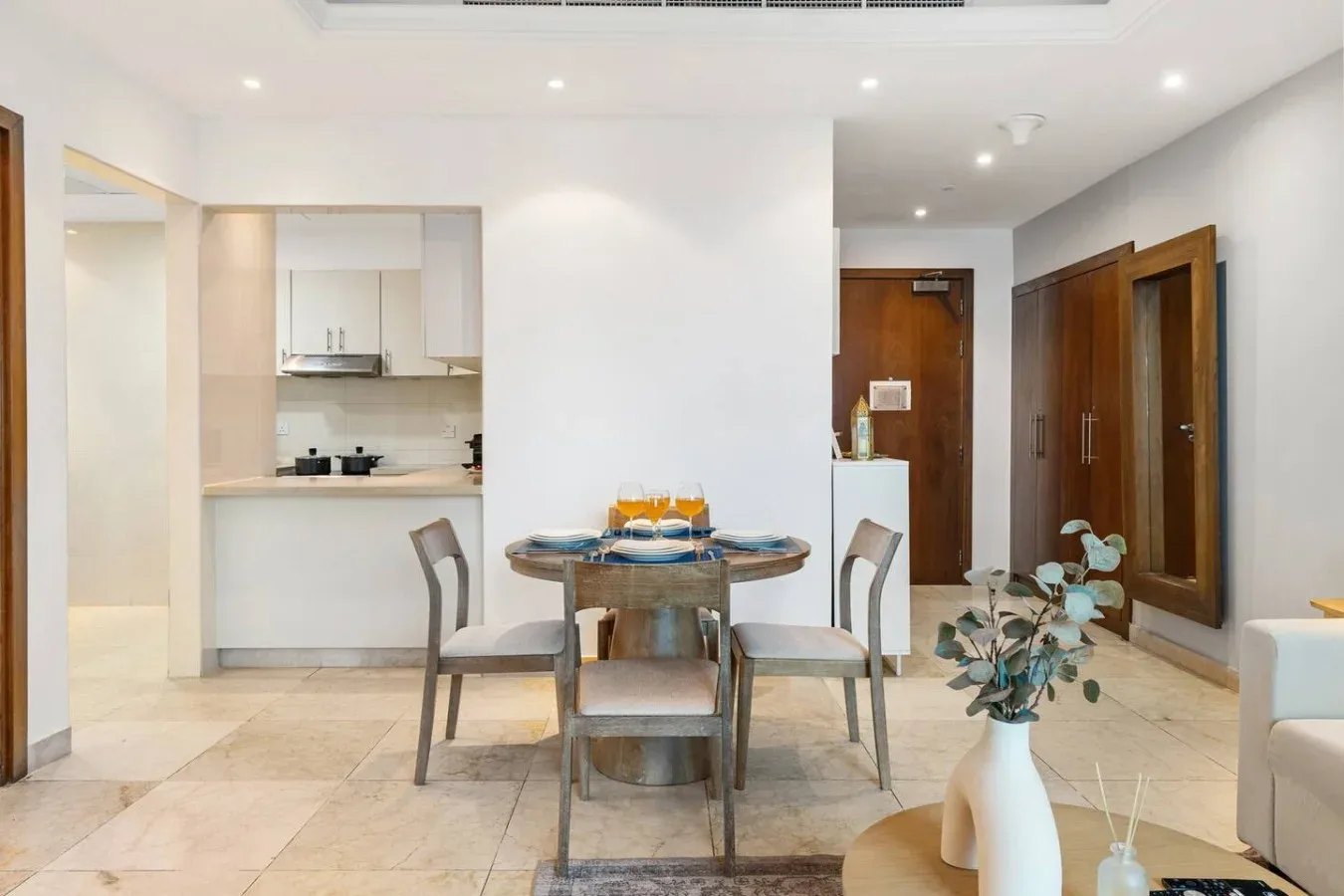Un comedor con una mesa redonda y una cocina pequeña al fondo.