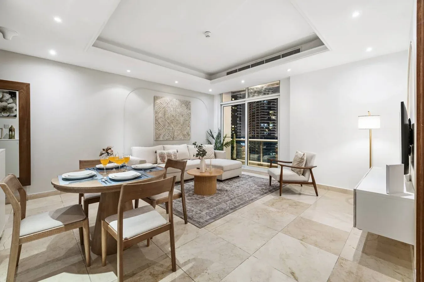 Un luminoso salón-comedor con zona de estar y mesa puesta.