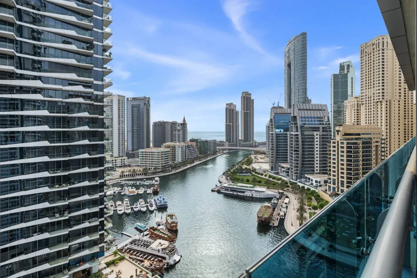 Desde un balcón se ven una marina urbana y un horizonte de edificios junto al agua.