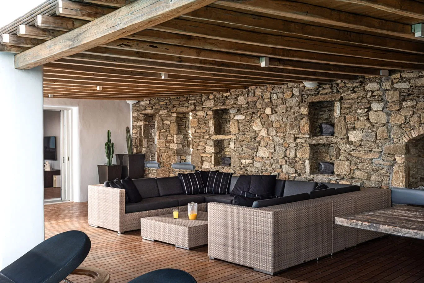 An open lounge with sectional seating and a rustic stone wall.
