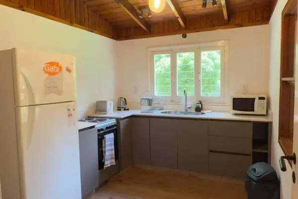 Una cocina con gabinetes oscuros y una ventana sobre el fregadero.