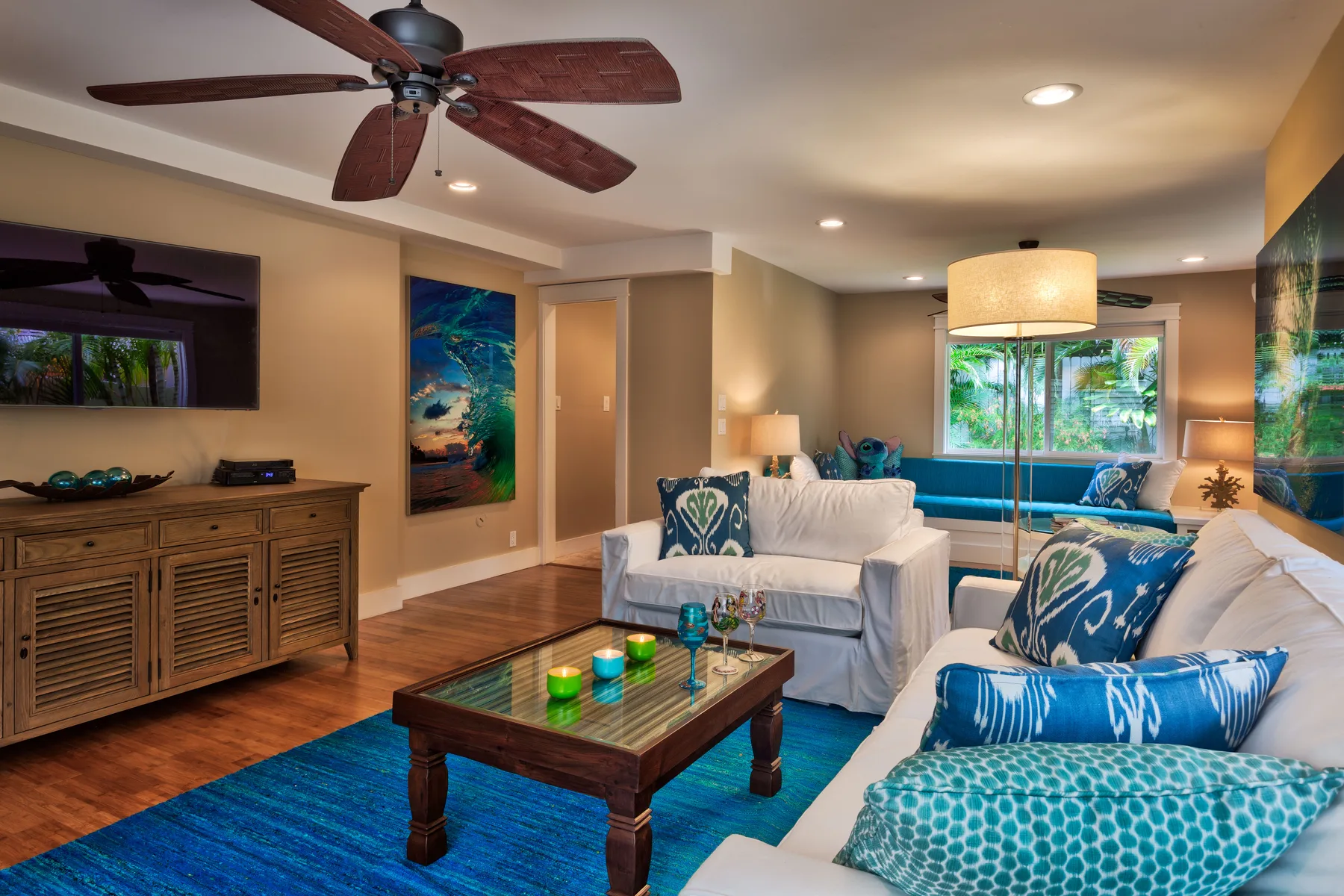 A living room with light-colored seating, a wooden coffee table, and a blue rug.