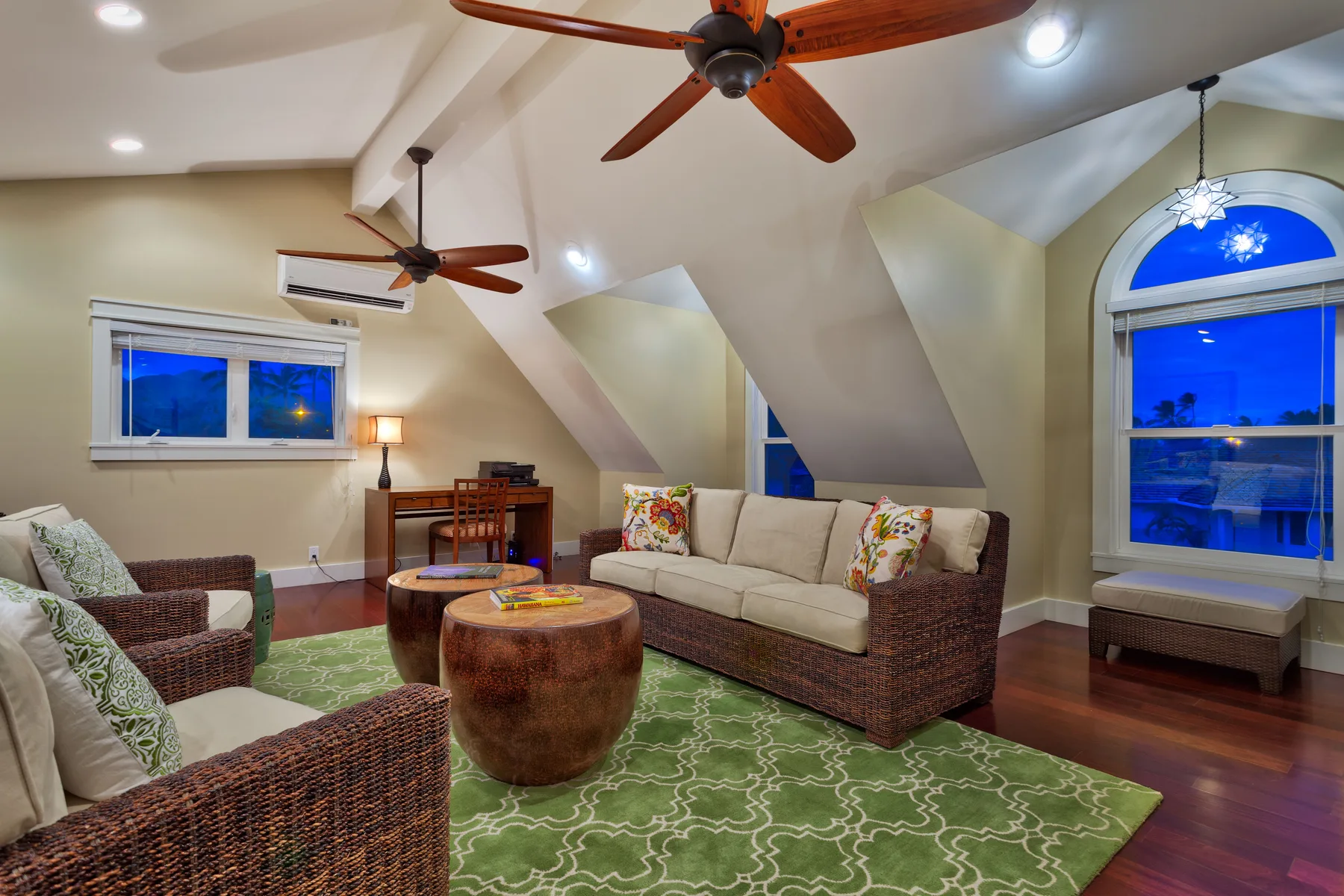A living room with seating arranged around a coffee table on a patterned rug.
