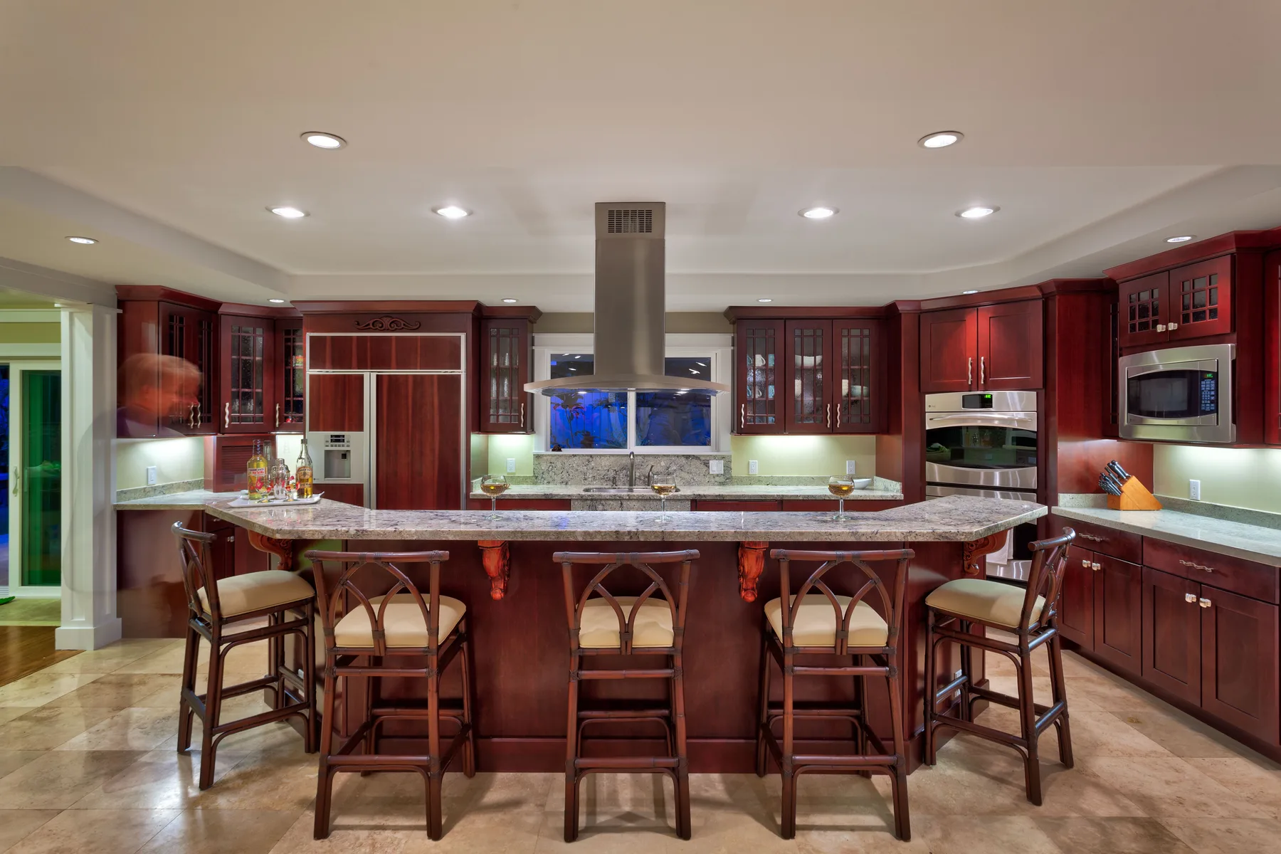 A spacious kitchen with dark wood cabinets and a large island with bar seating.
