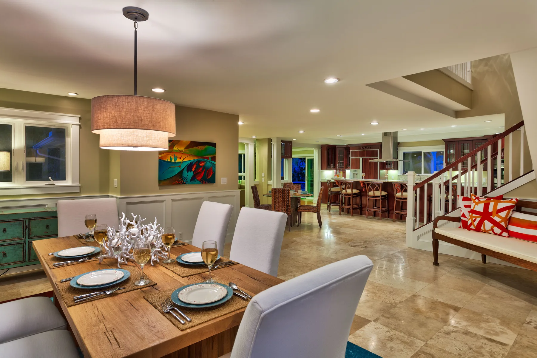 An open-plan dining and kitchen area with a wooden dining table and counter seating.
