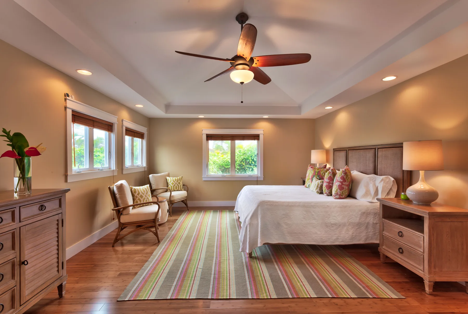 A bedroom with a large bed, bedside tables, and a striped rug.