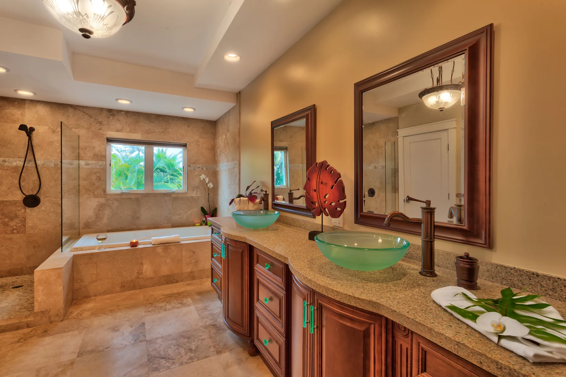 A spacious bathroom with a bathtub, glass shower, and long vanity.