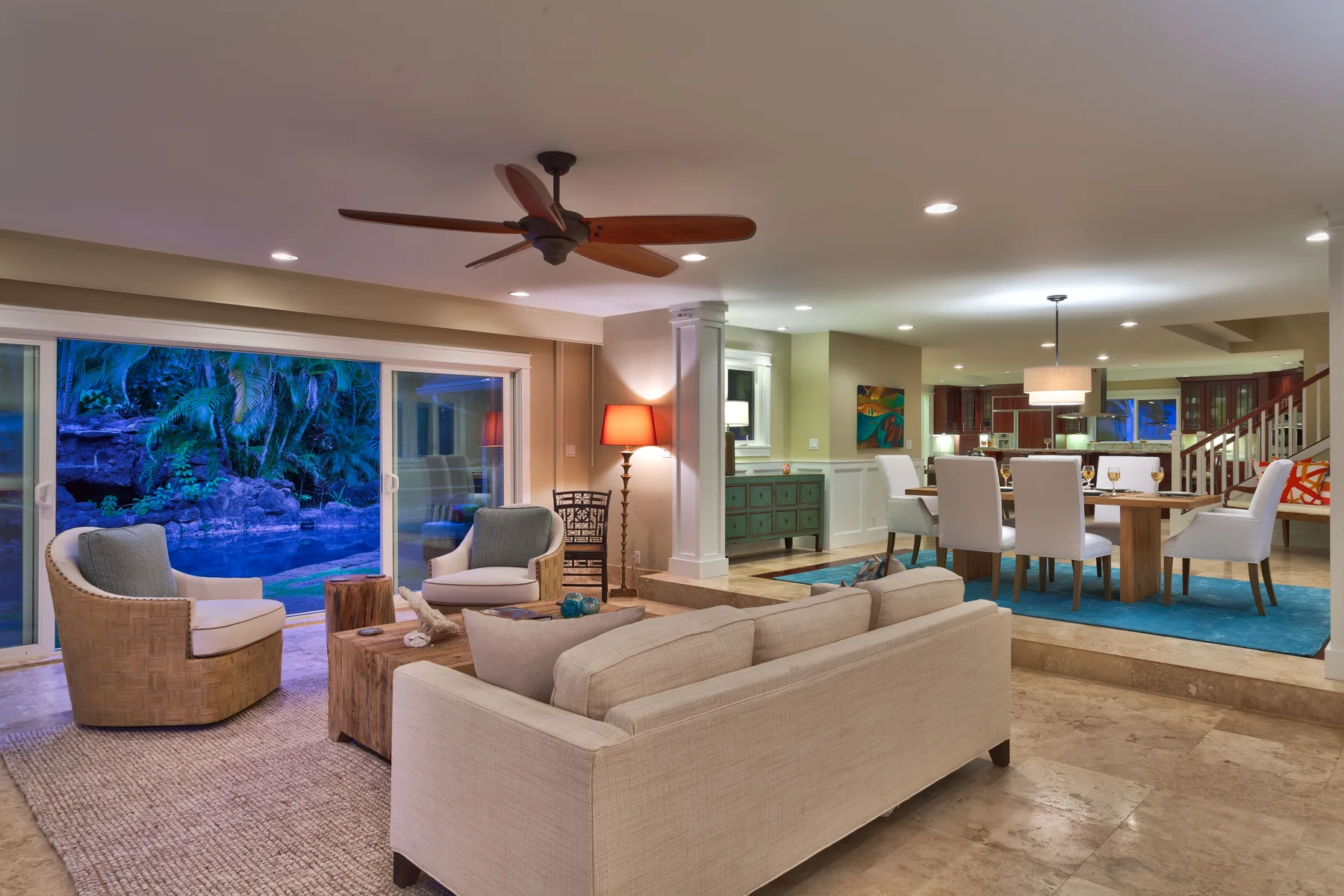 A living room with light-colored seating beside an open dining area.