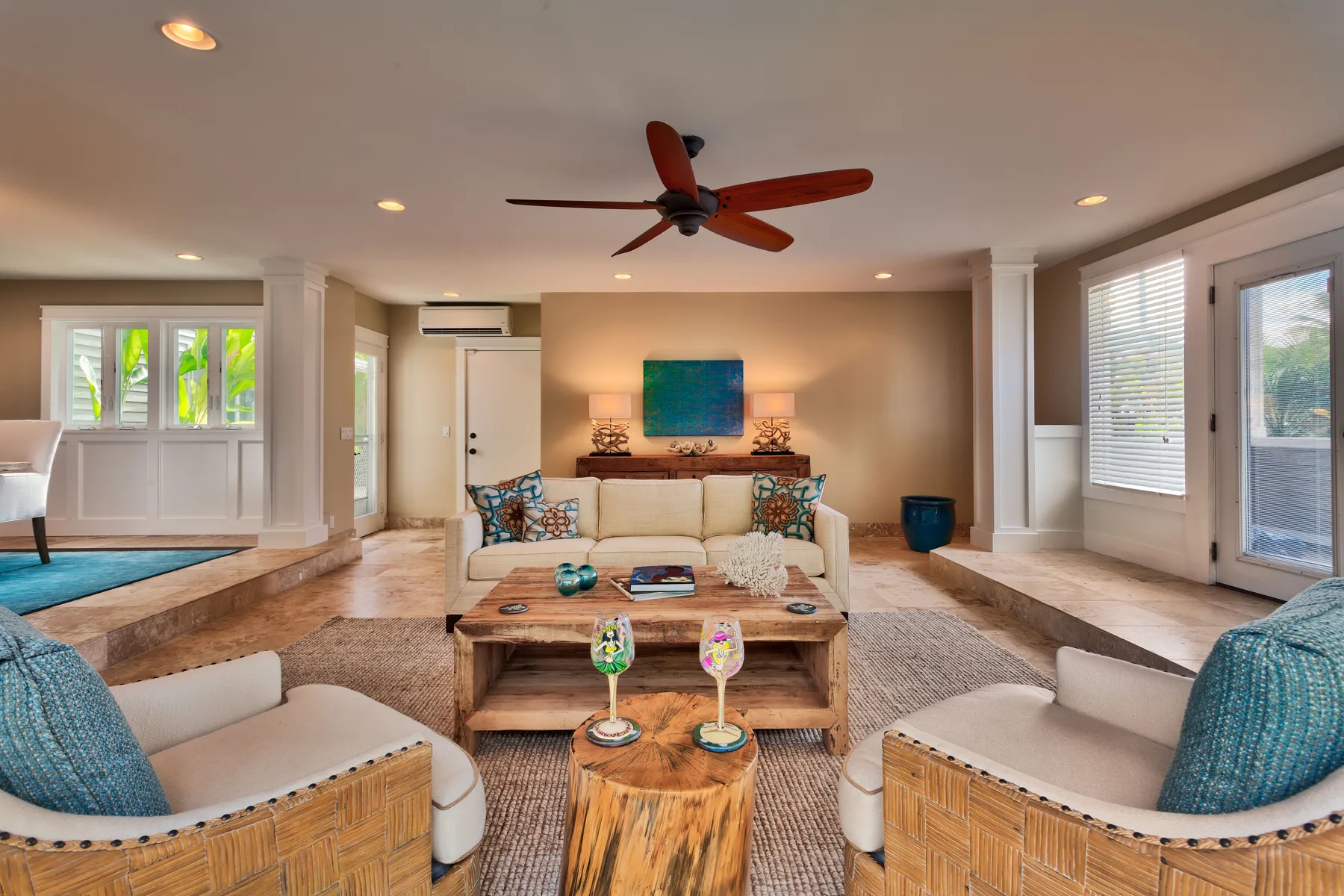 A bright living room with seating arranged around a coffee table and television.