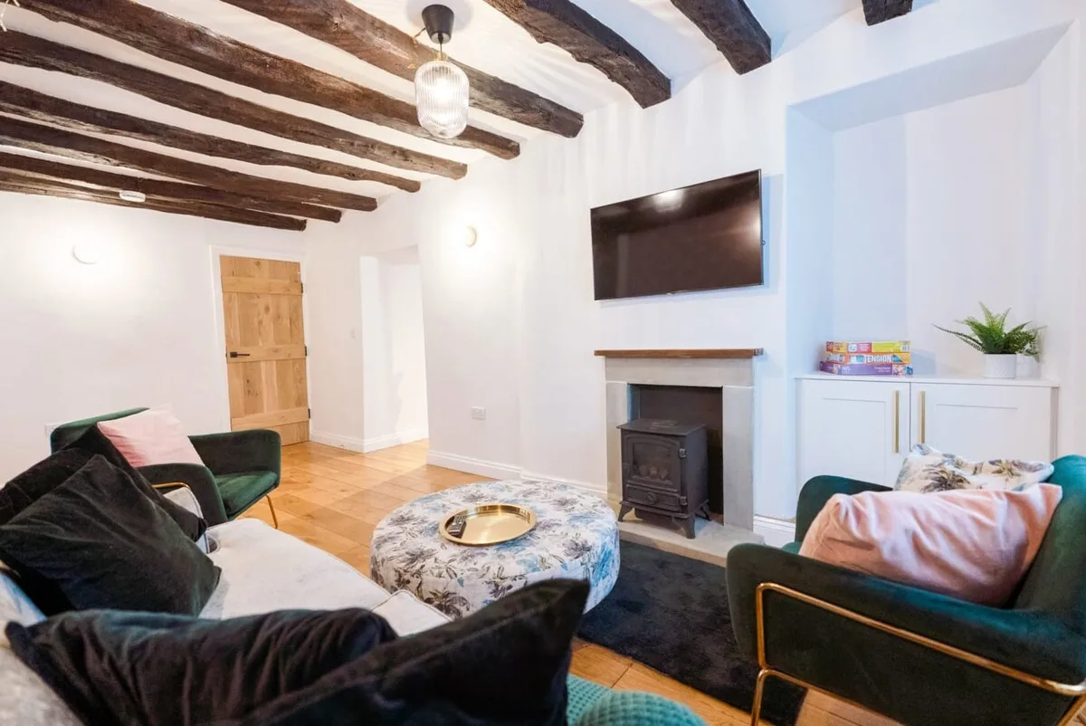Una sala de estar con asientos alrededor de una chimenea y un televisor en la pared.