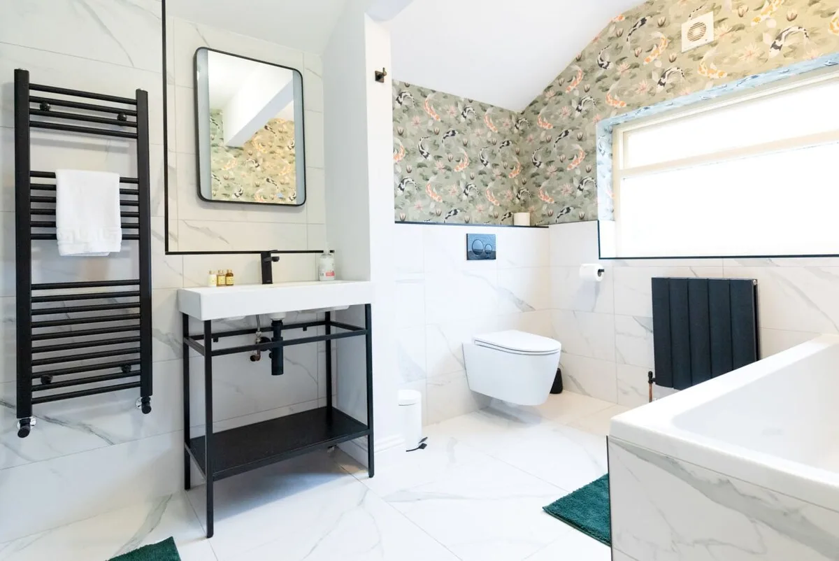 Un baño luminoso con lavabo, inodoro y bañera.