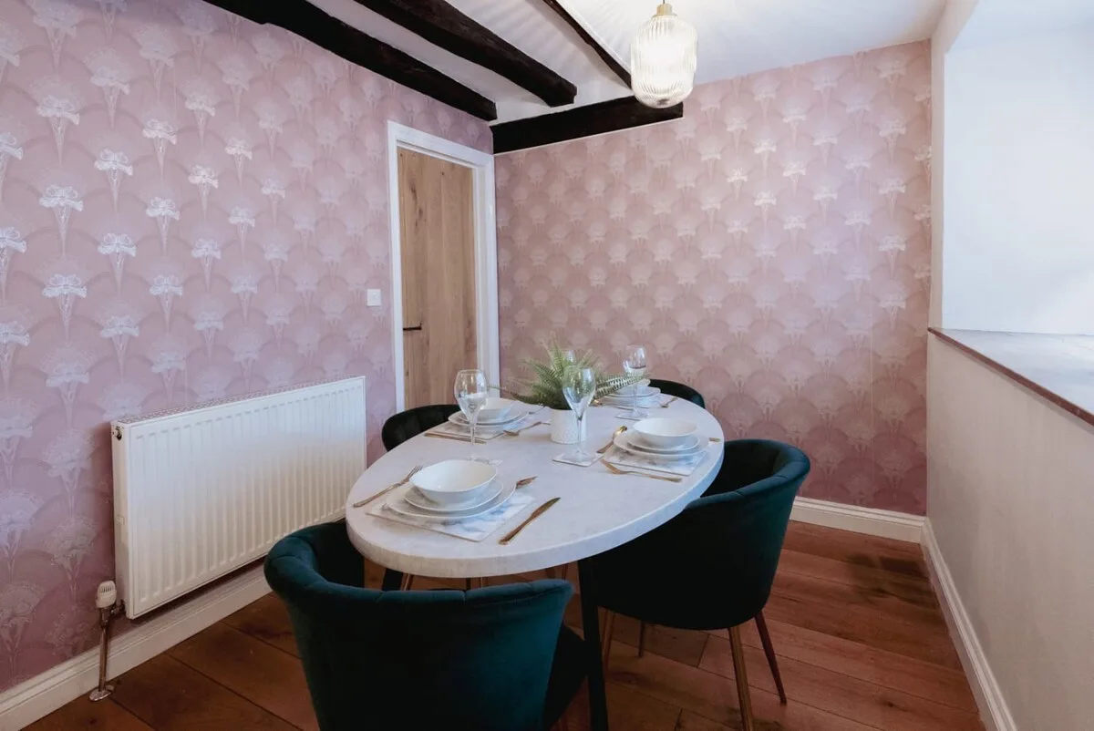 Comedor con una mesa puesta con vajilla y rodeada de asientos.