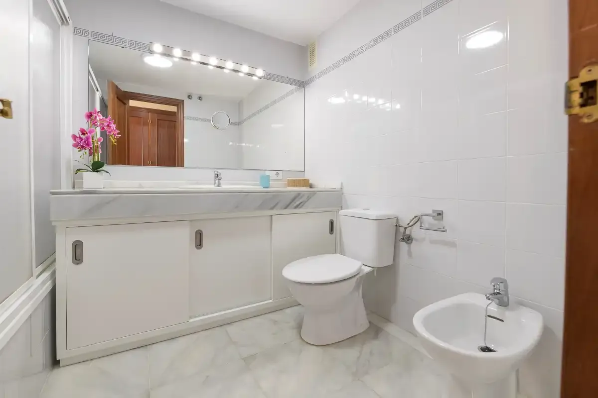 Un baño con mueble de lavabo, inodoro y bidé.
