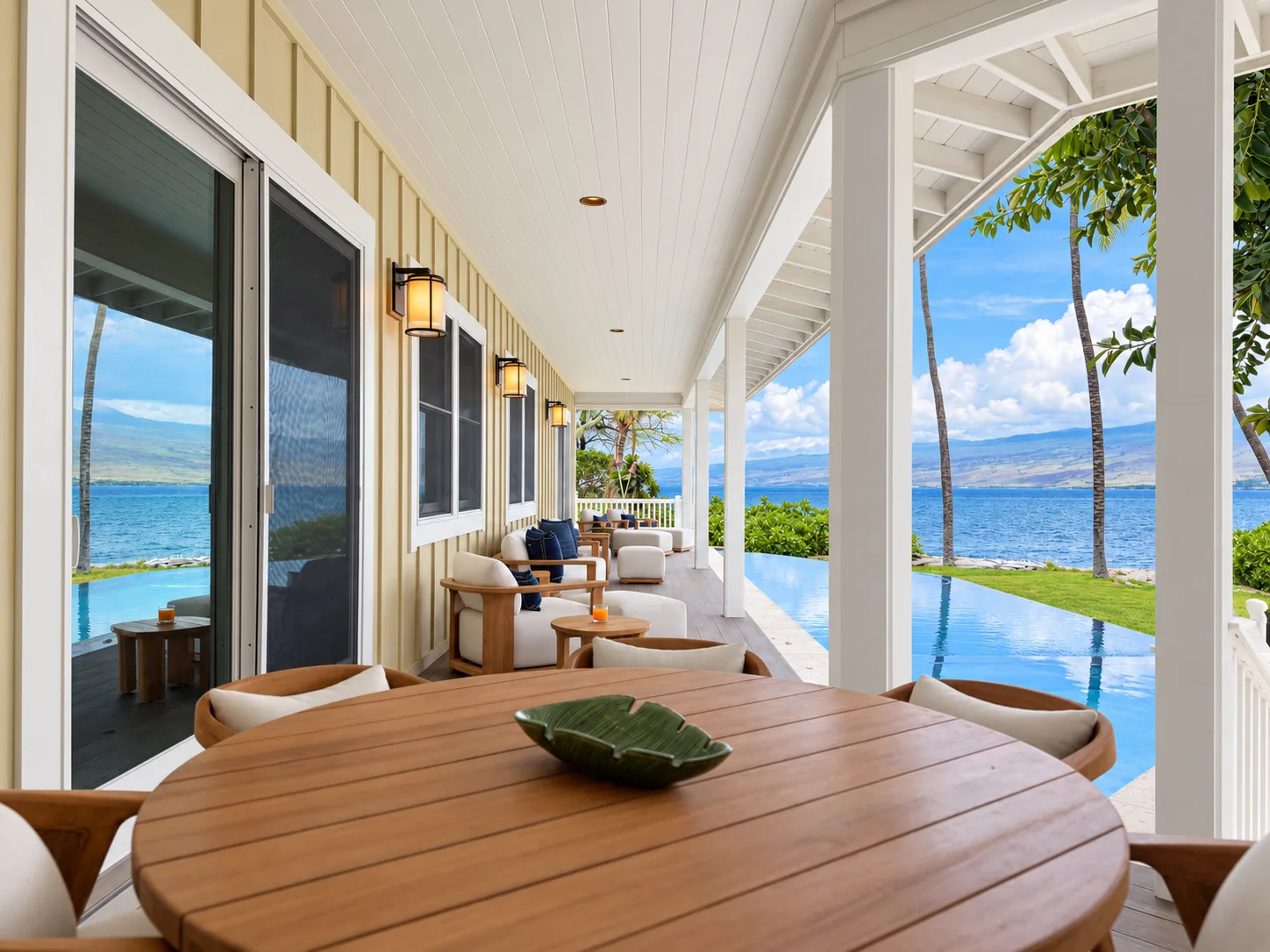 Un patio cubierto junto al agua tiene asientos de madera y vistas al agua.