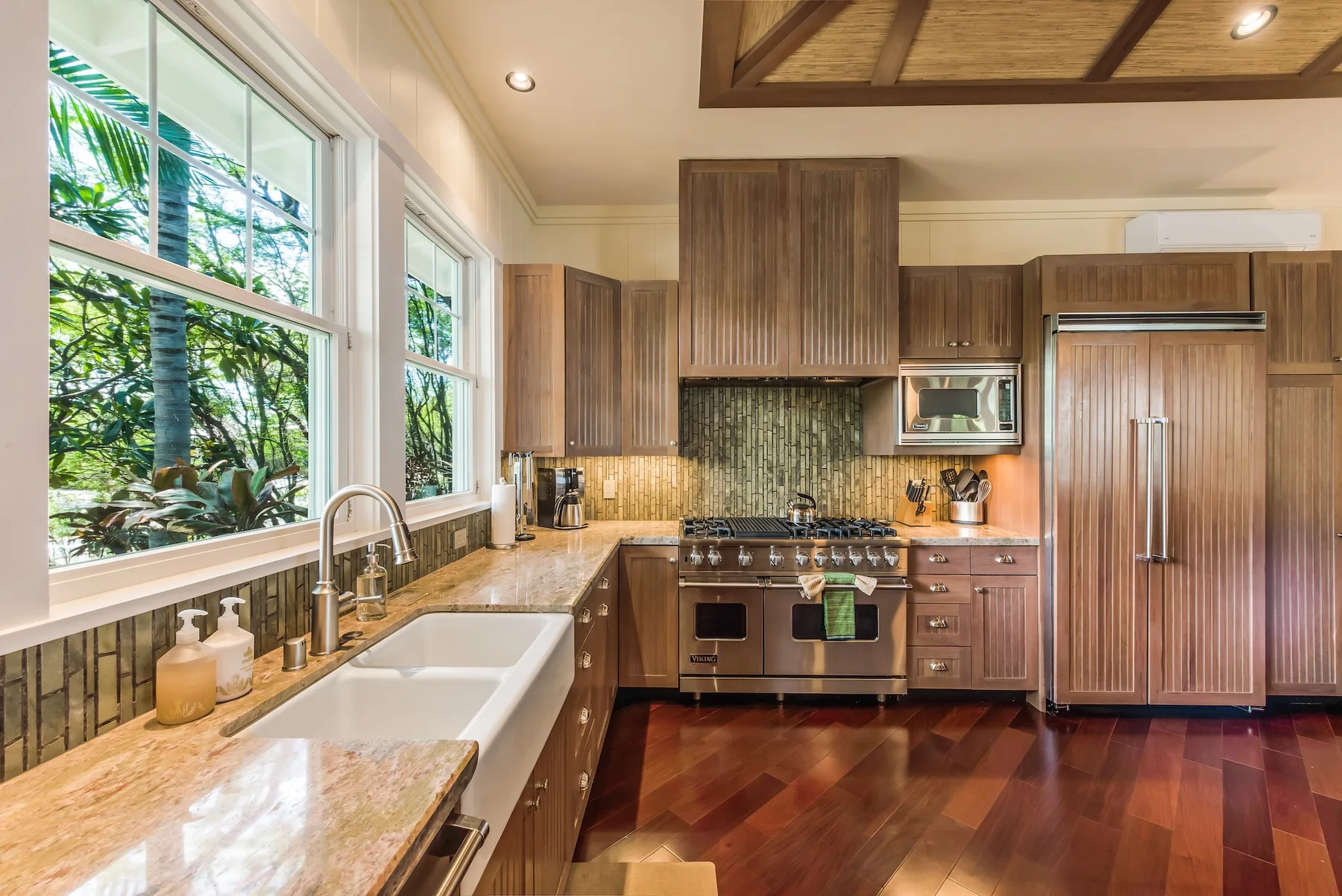 Una cocina luminosa con gabinetes de madera, un fregadero amplio y una estufa.