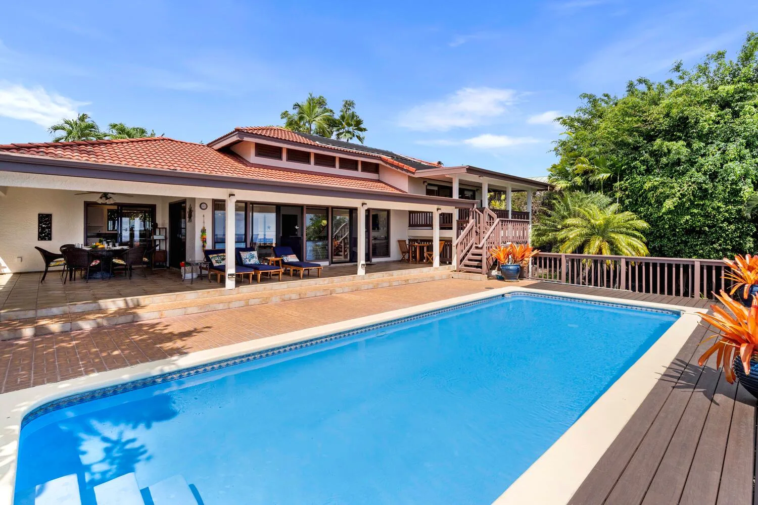 Una piscina junto a un patio de baldosas y una casa.