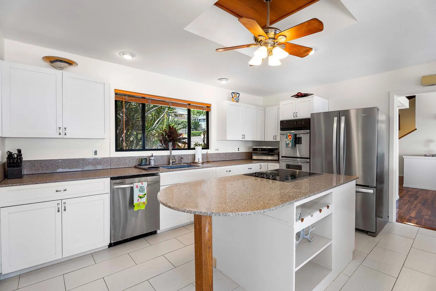 Una cocina luminosa con gabinetes blancos y una isla grande.