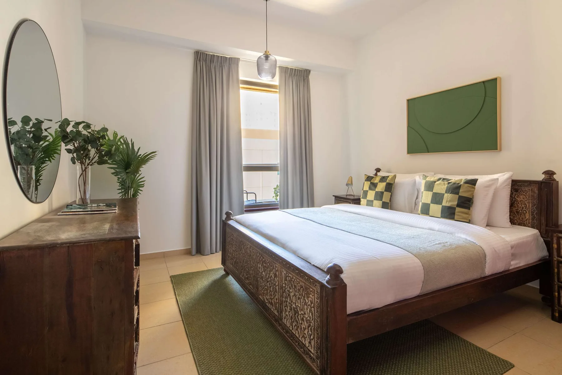 Un dormitorio con una cama grande, una ventana y cortinas.