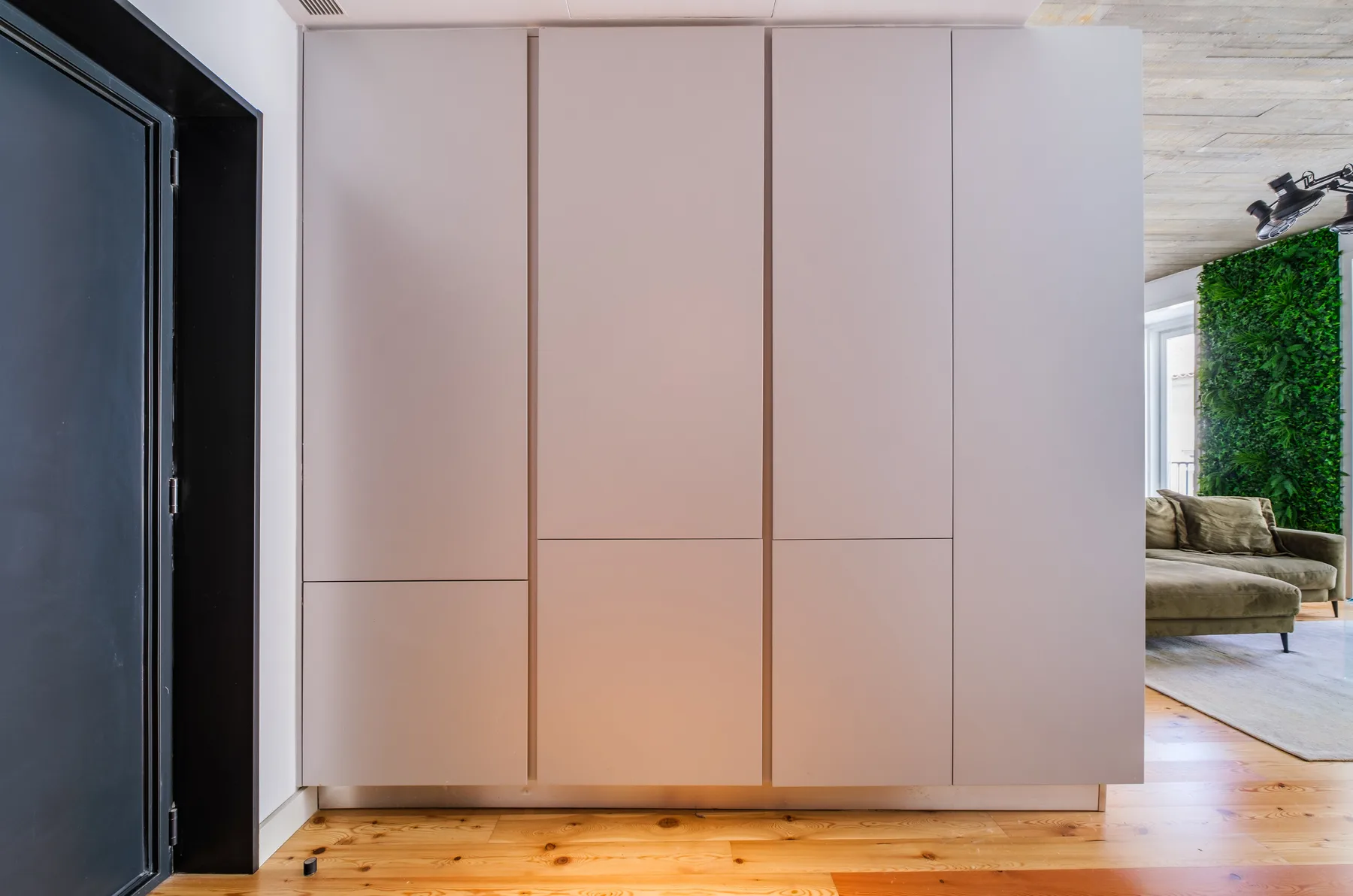 A large built-in cabinet stands beside the entrance to a living area.