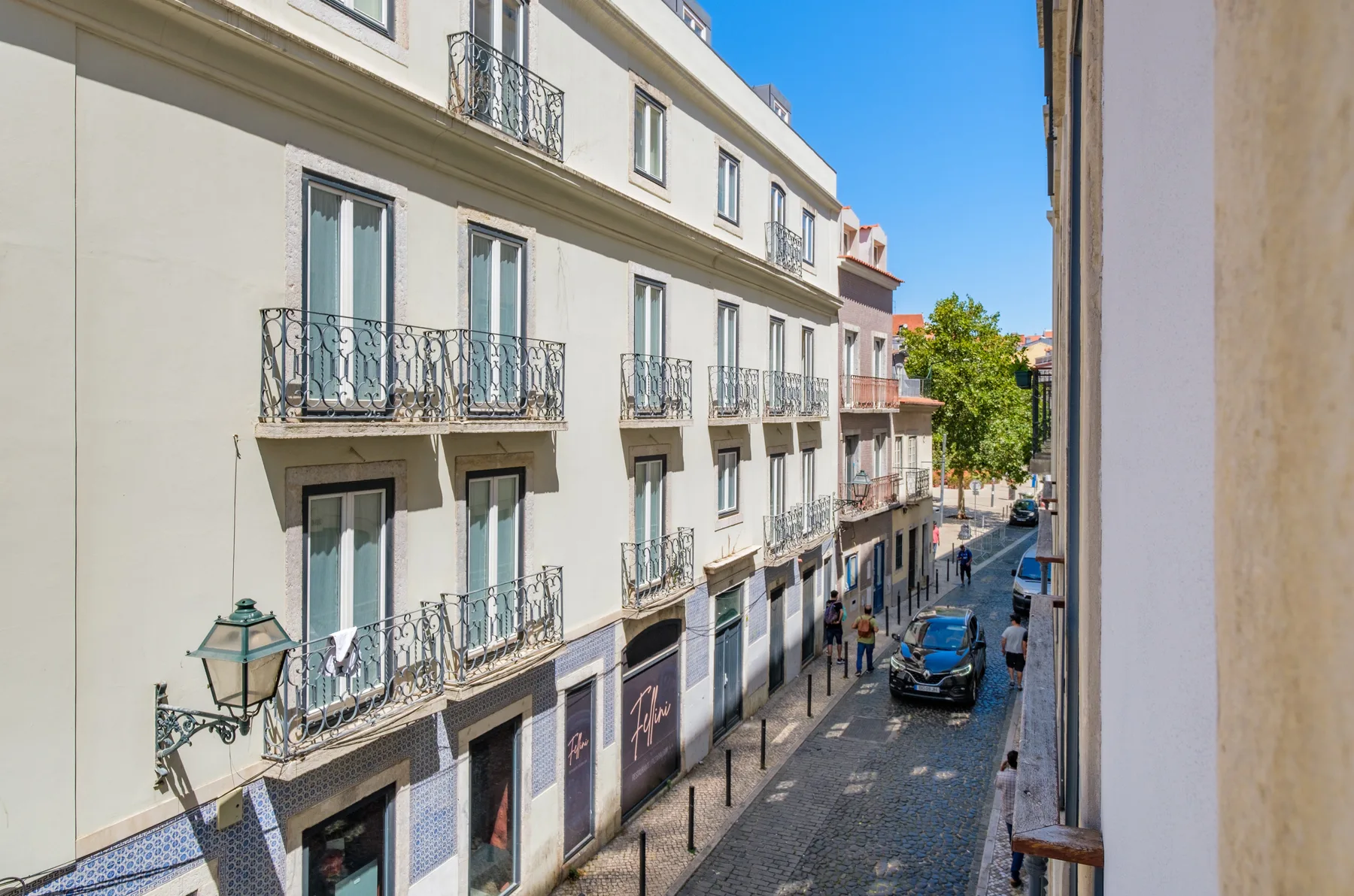 A narrow city street lined with multi-story buildings and balconies.