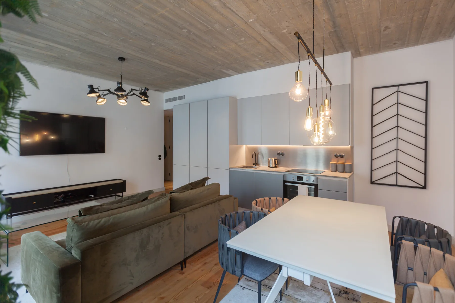 Living and dining area with a kitchen, table, and seating.