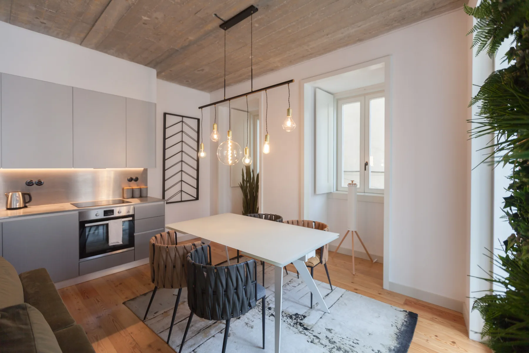 A dining area with a table and chairs beside a bright window.