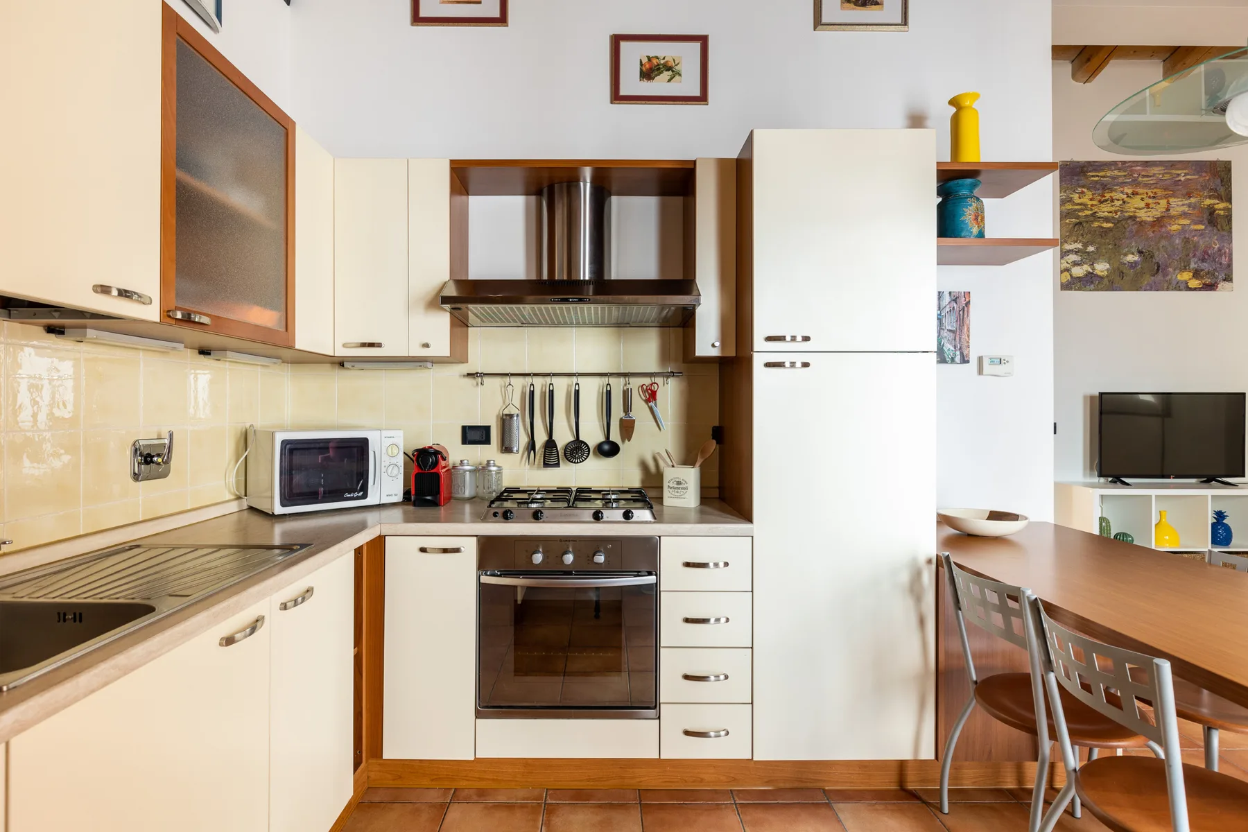 Una cocina con estufa y horno, abierta a un comedor.