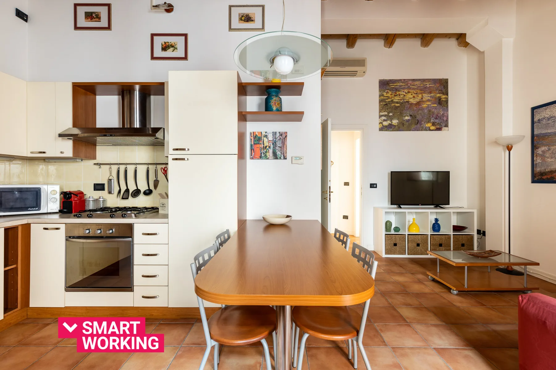 Una cocina abierta con comedor y una larga mesa junto a la zona de estar.