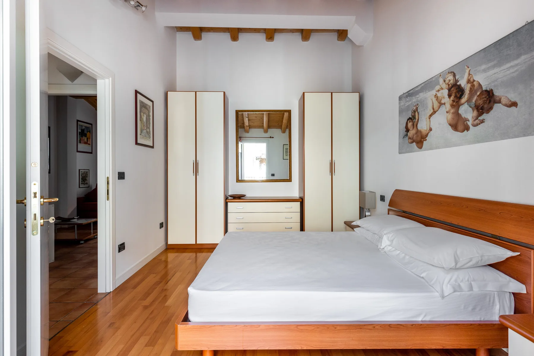 Un dormitorio con una cama bien tendida y armarios empotrados.