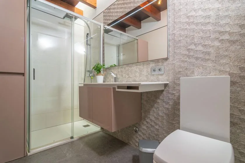 A modern bathroom with a glass shower and floating vanity.