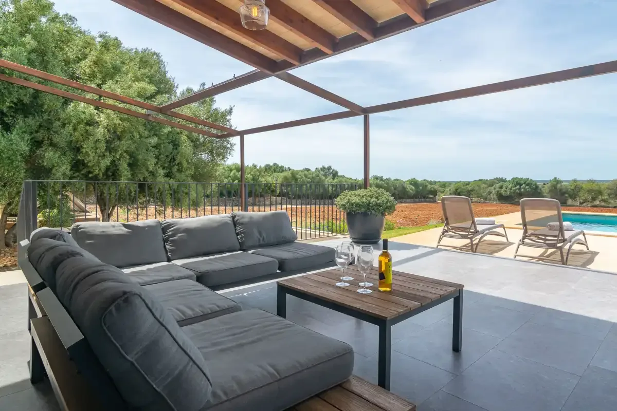 A covered outdoor seating area overlooks a garden and open countryside.