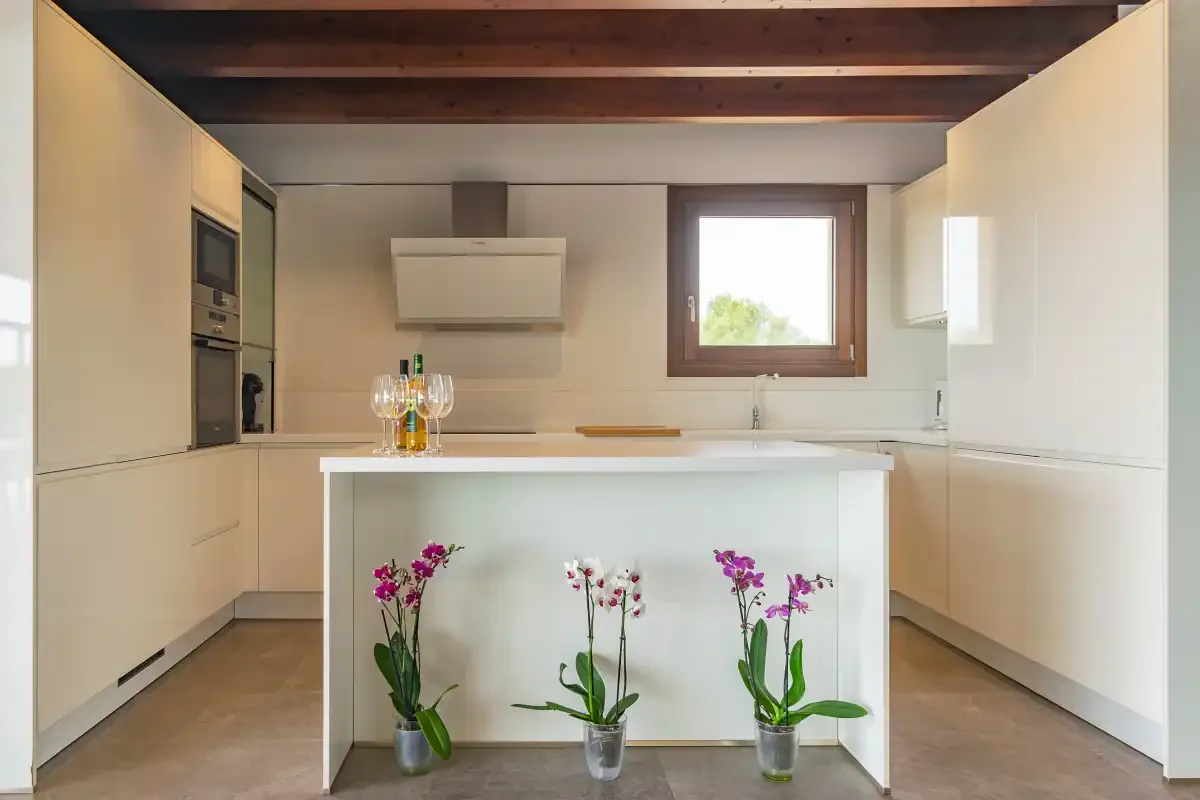 A modern kitchen with a central island and flowers.