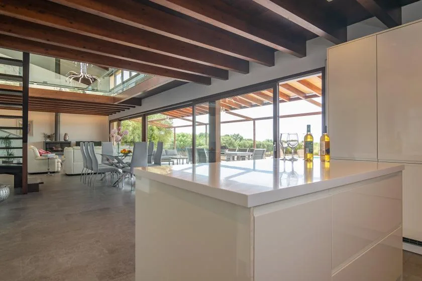An open-plan kitchen and dining area with large glass doors opening onto a patio.