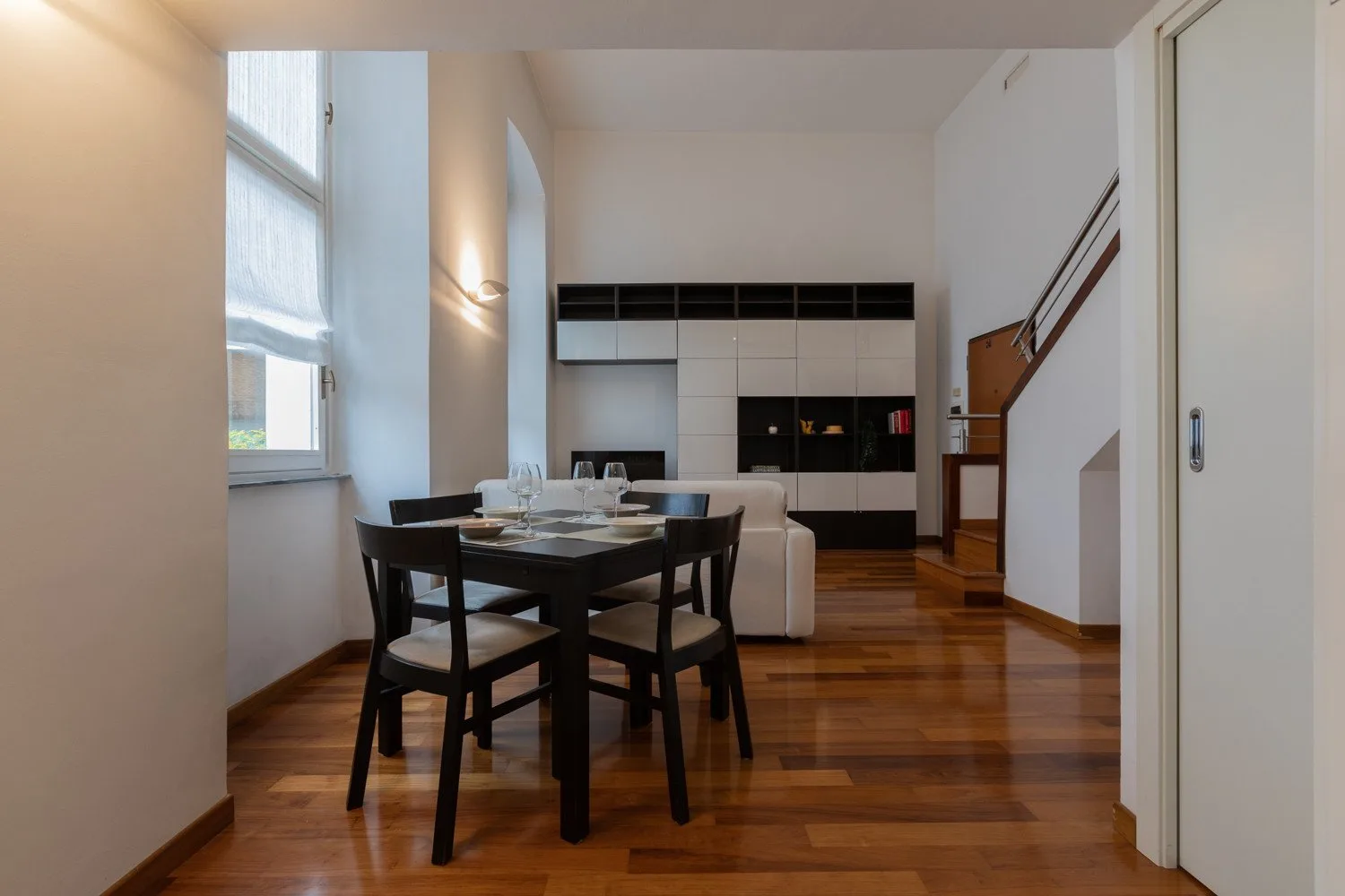 Un comedor con mesa y sillas da a una cocina compacta.