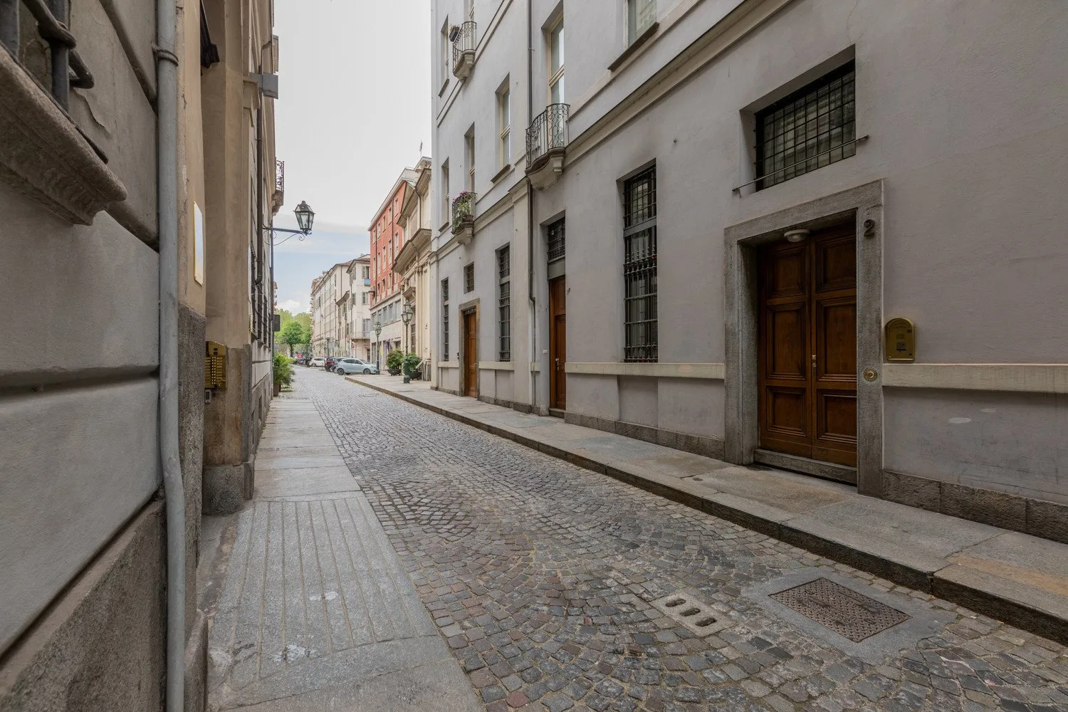 Una calle estrecha empedrada pasa entre hileras de edificios muy próximos.