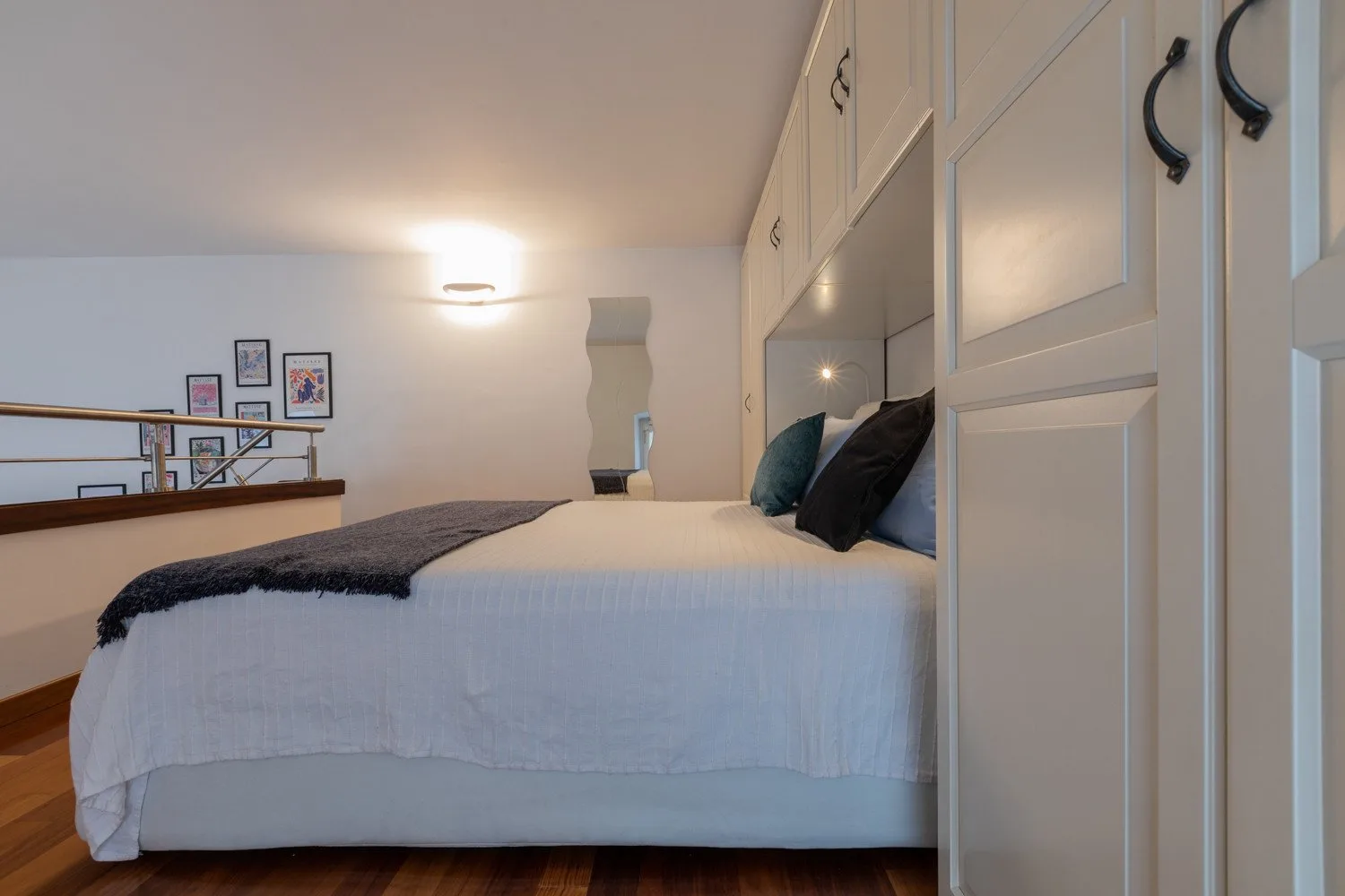 Un dormitorio con una cama tendida y armarios empotrados.