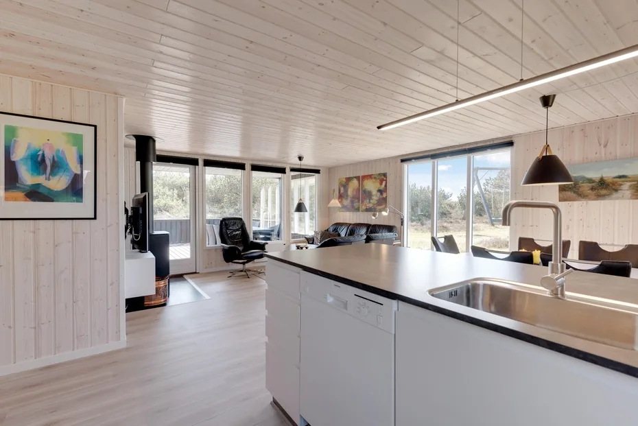 A bright open-plan kitchen and living area with a large island and windows.