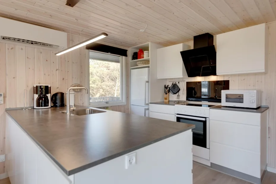 A bright kitchen with white cabinetry and a broad island counter.