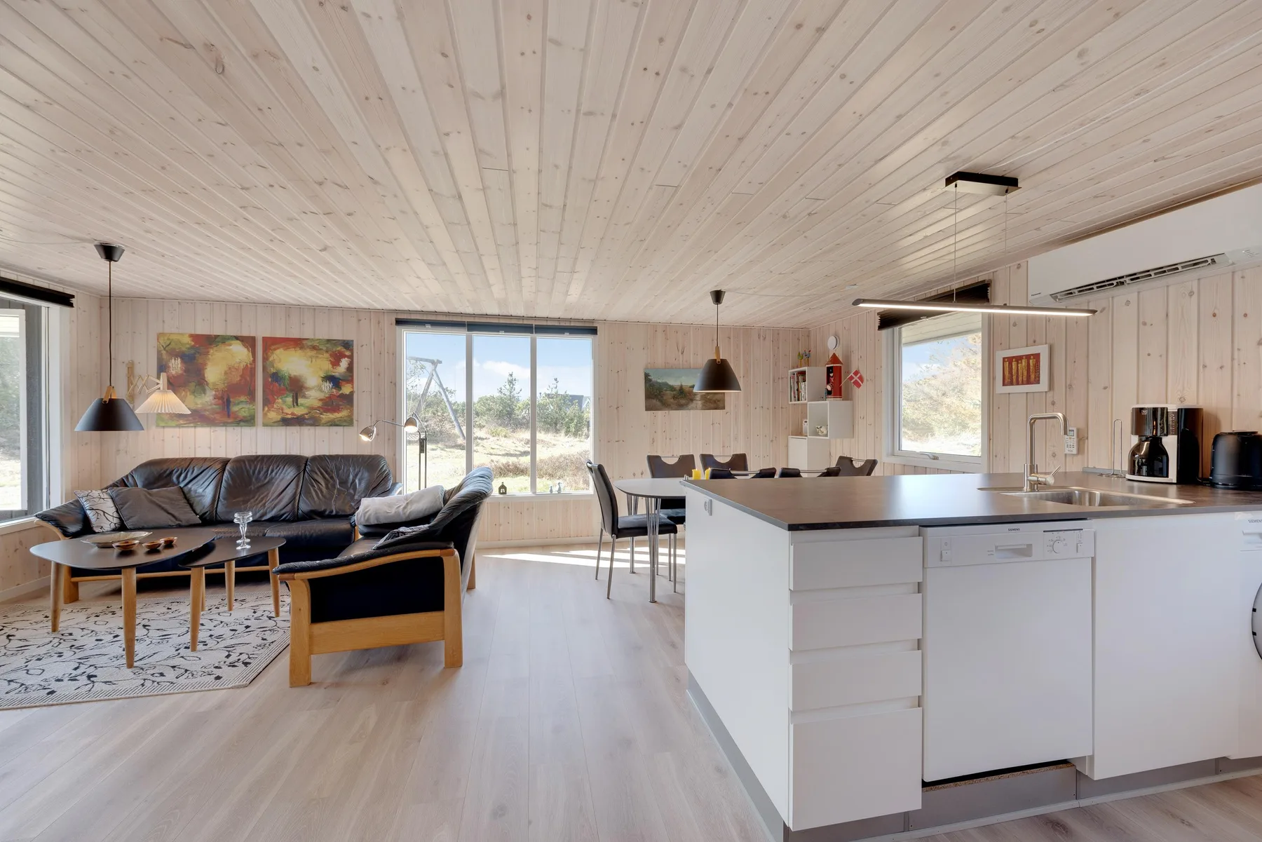 Open-plan living area with seating, a dining table, and a kitchen island.