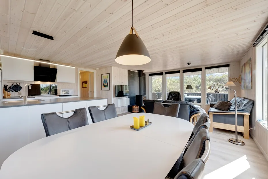 An open-plan kitchen and dining area with a large table and seating.